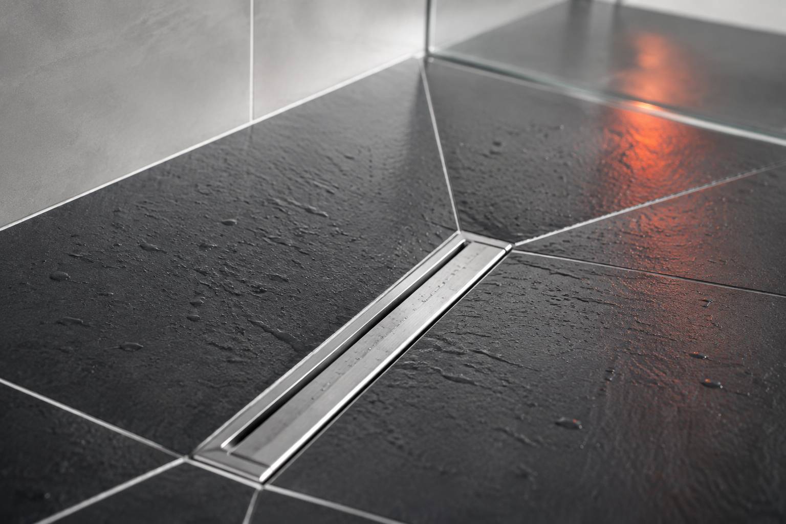 Carrelage antidérapant en pente vers une bonde linéaire en acier