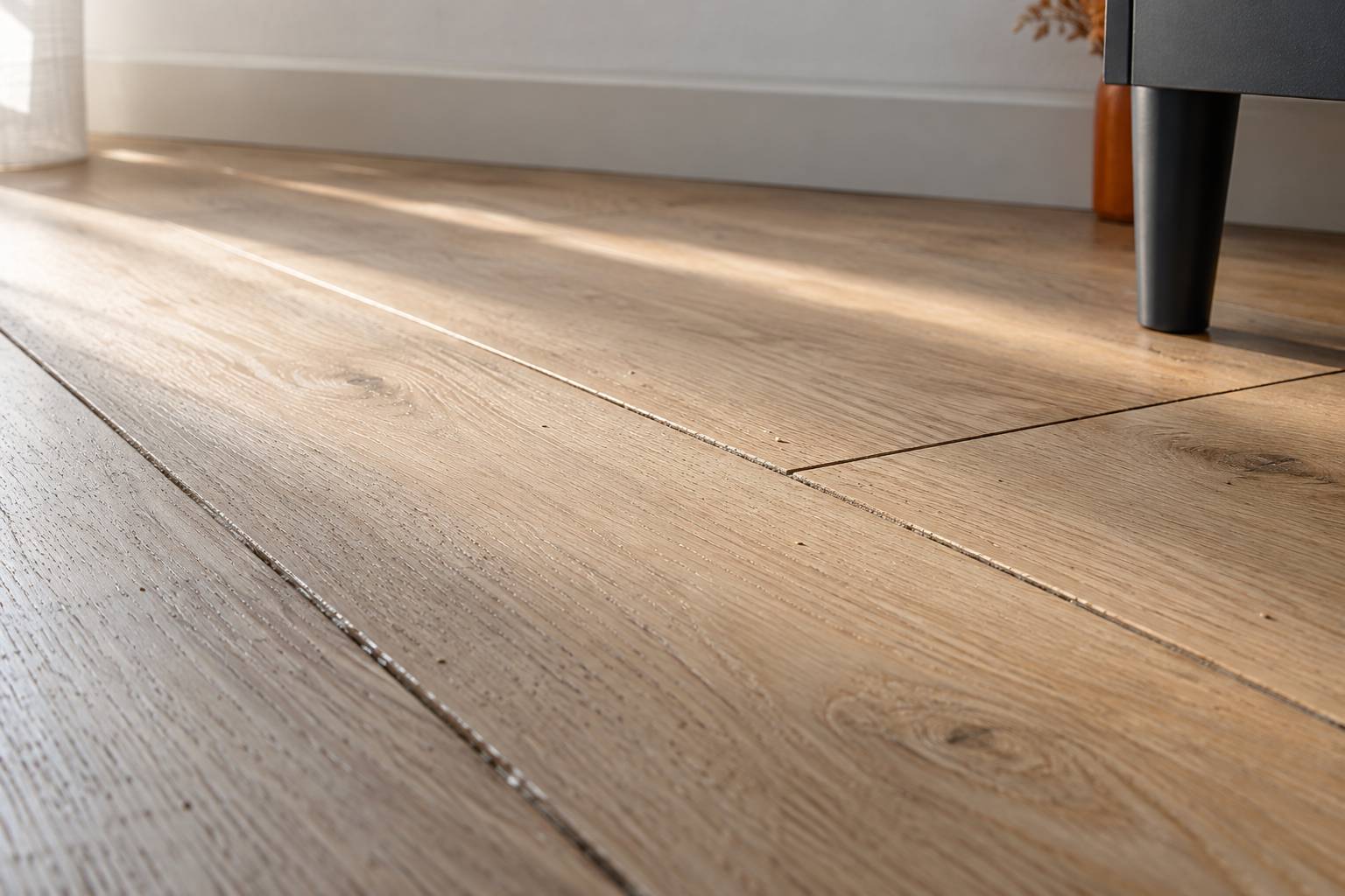 Fentes d'un parquet en bois clair vues de pres sous une lumiere rasante